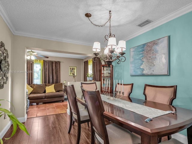 dining area with crown molding, a healthy amount of sunlight, and a textured ceiling