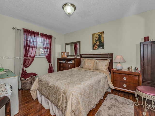 bedroom featuring a textured ceiling and dark hardwood / wood-style floors