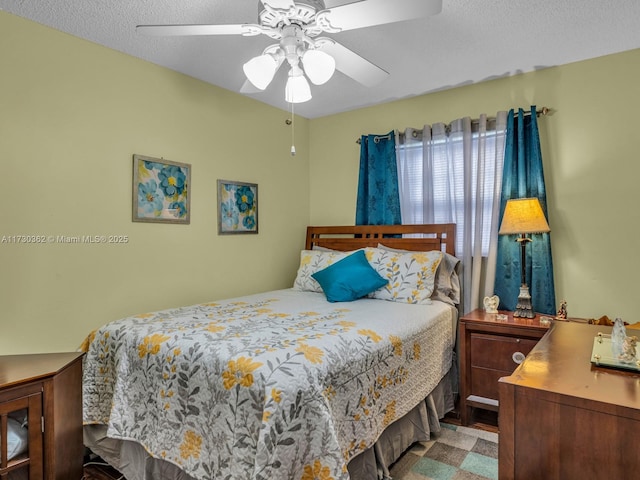 bedroom with ceiling fan and a textured ceiling