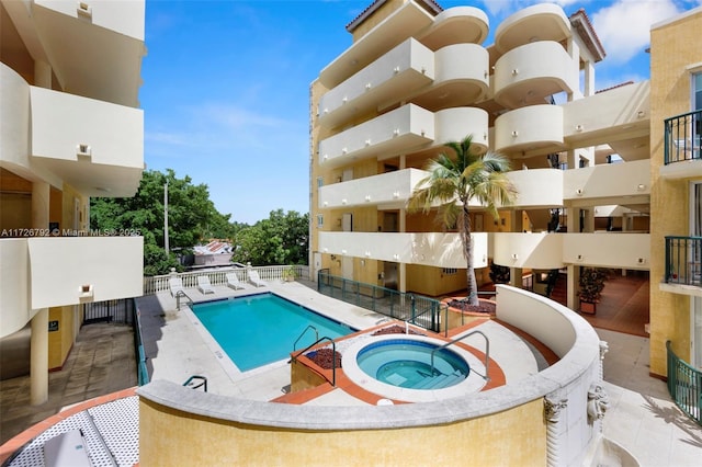 view of swimming pool with a patio and a hot tub