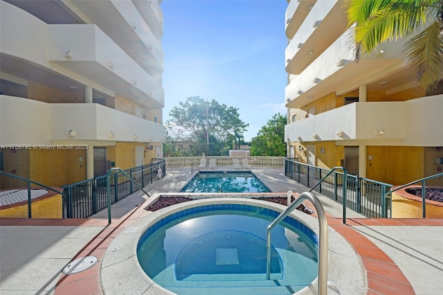 view of pool with a hot tub