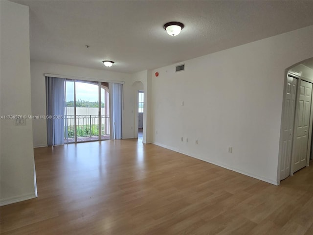 spare room with light hardwood / wood-style floors and a textured ceiling