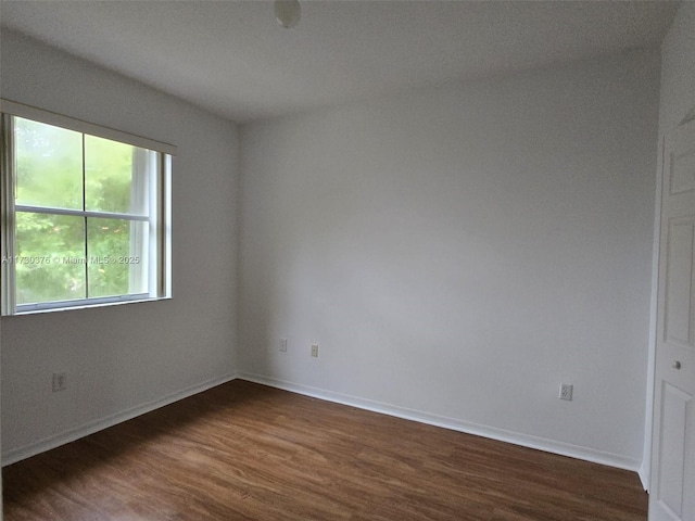 unfurnished room with dark hardwood / wood-style floors