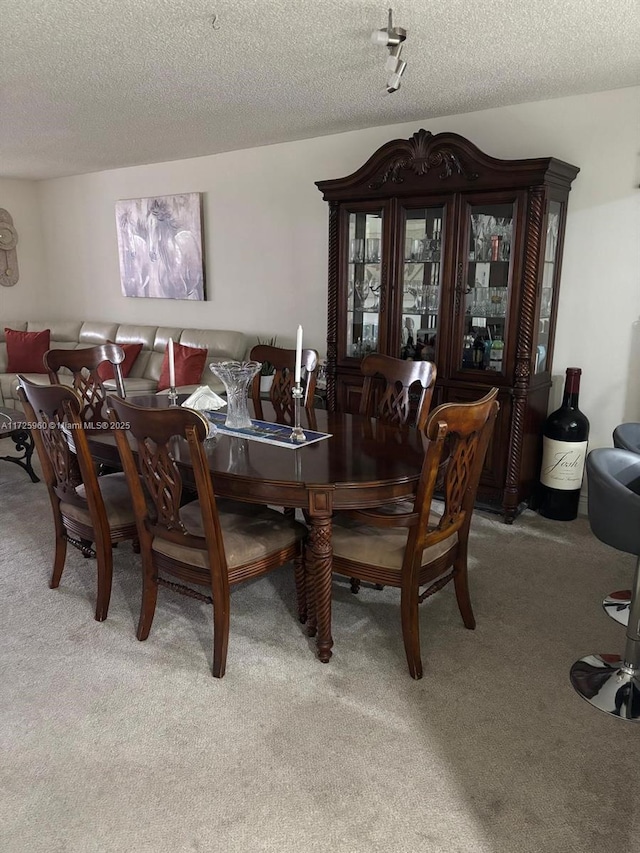 dining room featuring a textured ceiling and light colored carpet