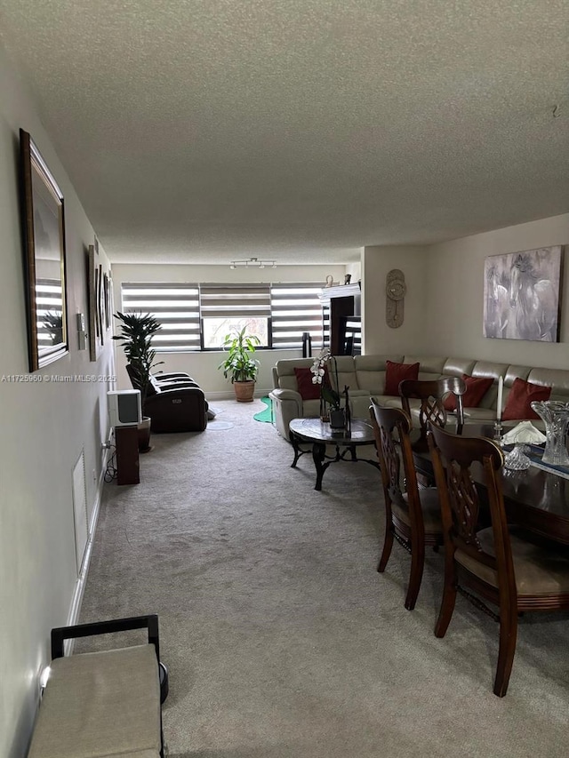 dining area featuring carpet floors and a textured ceiling