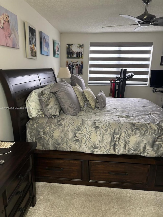 bedroom featuring light carpet, ceiling fan, a textured ceiling, and multiple windows