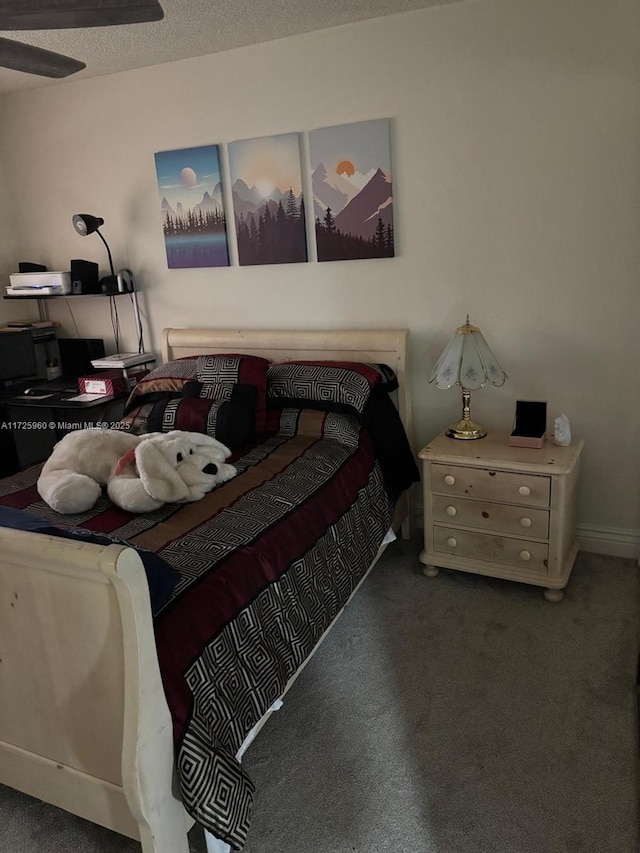 bedroom with dark colored carpet, a textured ceiling, and ceiling fan