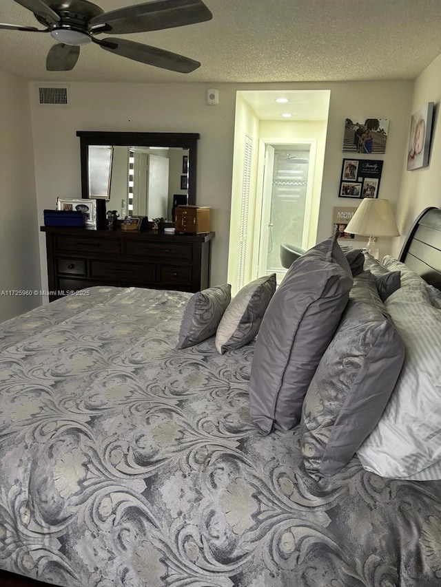 bedroom with ceiling fan and a textured ceiling