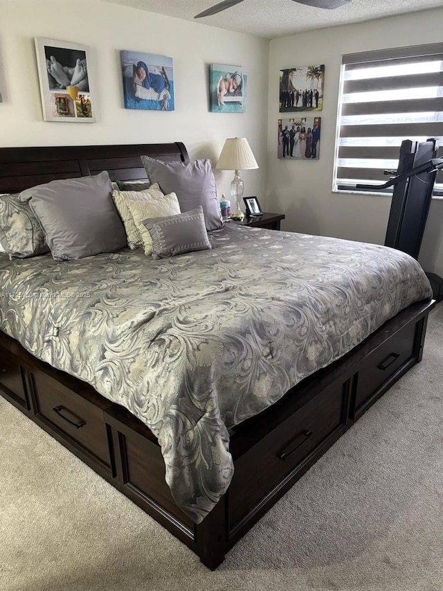 carpeted bedroom featuring ceiling fan and a textured ceiling