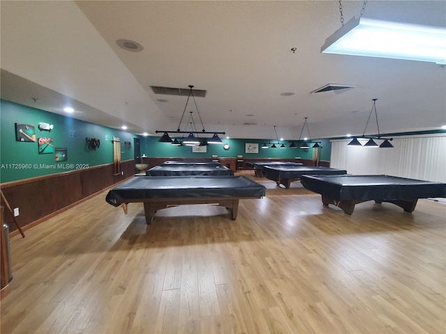 game room with wooden walls, light hardwood / wood-style floors, and pool table