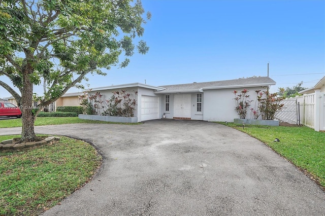 single story home with a garage and a front lawn