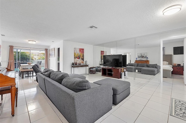 living room with a textured ceiling and light tile patterned floors