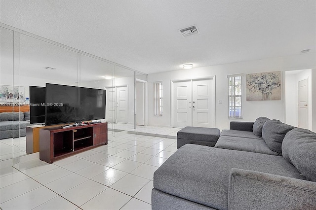 tiled living room featuring a textured ceiling