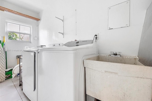 washroom with sink, light tile patterned floors, and independent washer and dryer