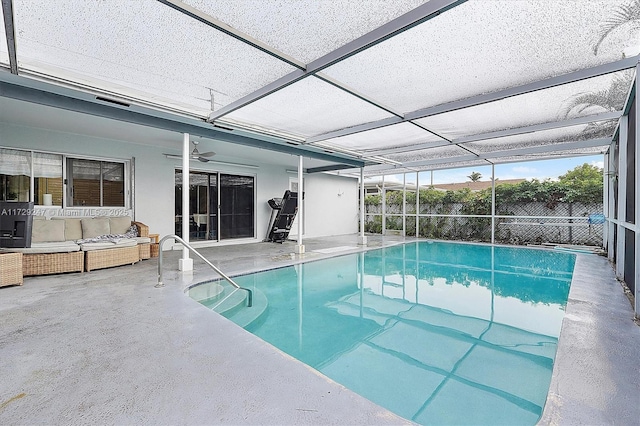 view of pool featuring an outdoor living space, a patio, glass enclosure, and ceiling fan