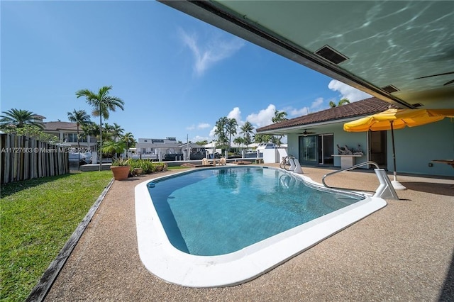 view of pool featuring ceiling fan, a patio area, and a lawn