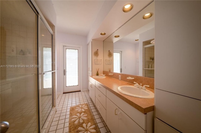 bathroom with vanity, a shower with shower door, and tile patterned floors