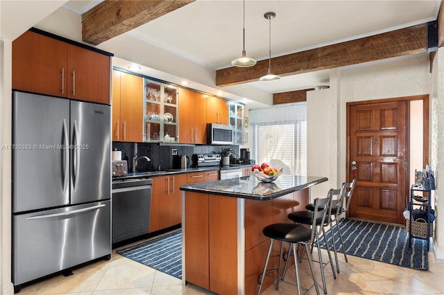 kitchen with stainless steel appliances, a breakfast bar area, decorative backsplash, and beamed ceiling