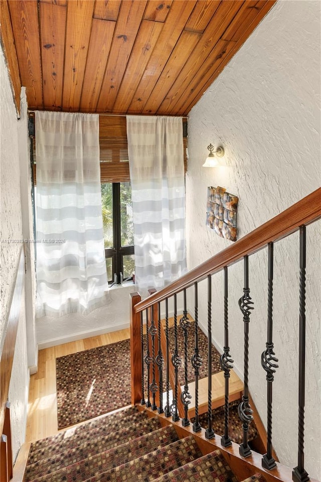 staircase featuring wood-type flooring and wood ceiling