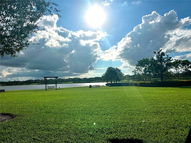 view of community with a yard and a water view