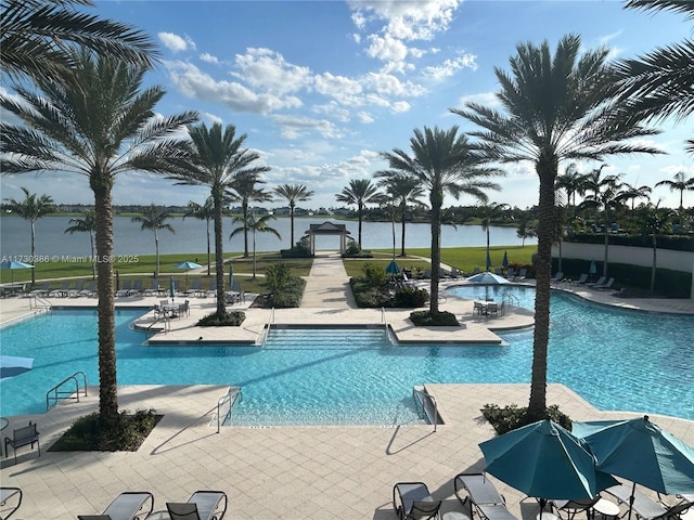 view of pool with a patio area and a water view