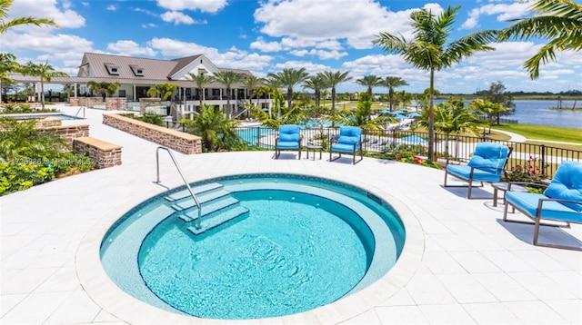 view of swimming pool with a patio and a water view