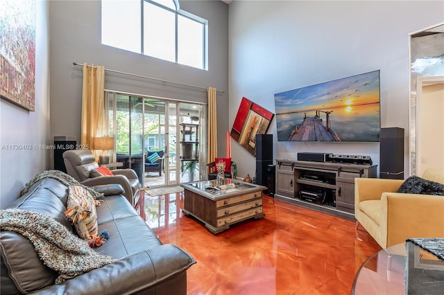 living room with concrete floors and a high ceiling