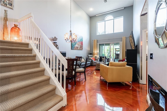 interior space with a high ceiling, a notable chandelier, and concrete flooring