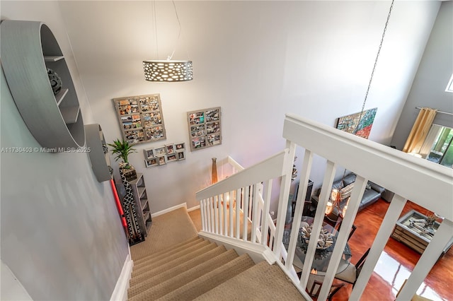 stairway with a chandelier and carpet