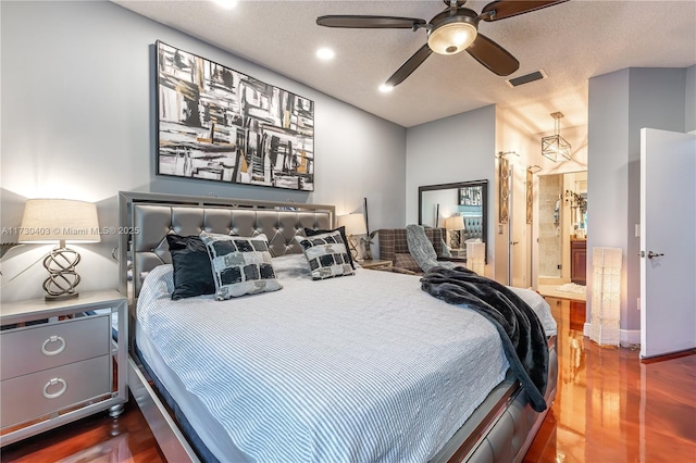 bedroom featuring a textured ceiling, dark wood-type flooring, ensuite bathroom, and ceiling fan