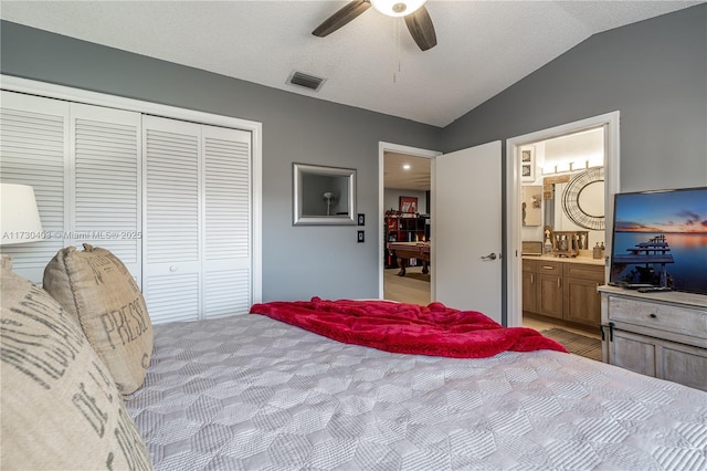 carpeted bedroom with ceiling fan, a textured ceiling, connected bathroom, a closet, and lofted ceiling