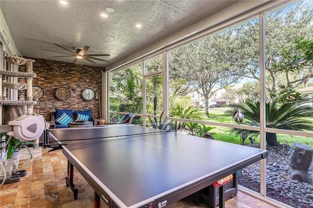 recreation room featuring a textured ceiling and ceiling fan