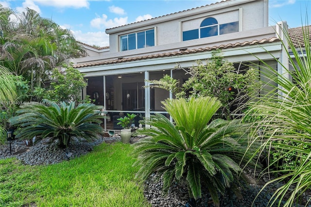 back of property with a sunroom