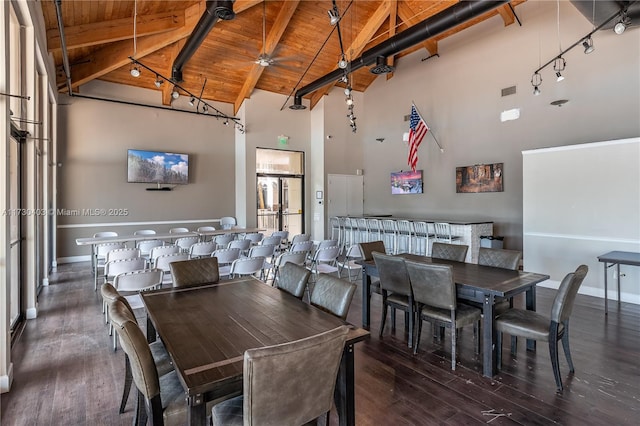 dining space with beamed ceiling, wooden ceiling, high vaulted ceiling, dark hardwood / wood-style flooring, and ceiling fan