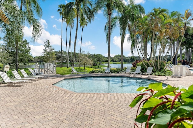 view of swimming pool featuring a water view and a patio