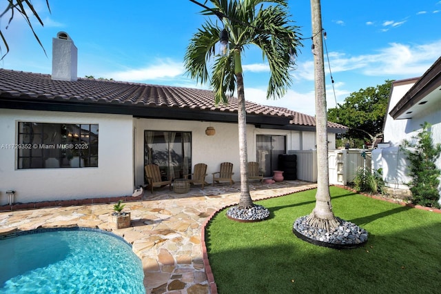 rear view of house featuring a patio and a yard