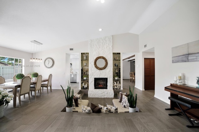 living room with dark wood-type flooring, lofted ceiling, and a fireplace