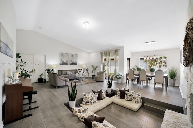 living room featuring a notable chandelier and vaulted ceiling