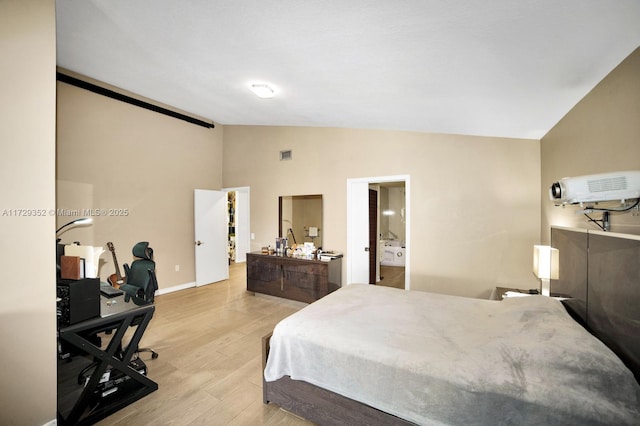 bedroom with light wood-type flooring and lofted ceiling