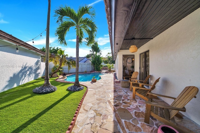 view of pool with a patio and a lawn