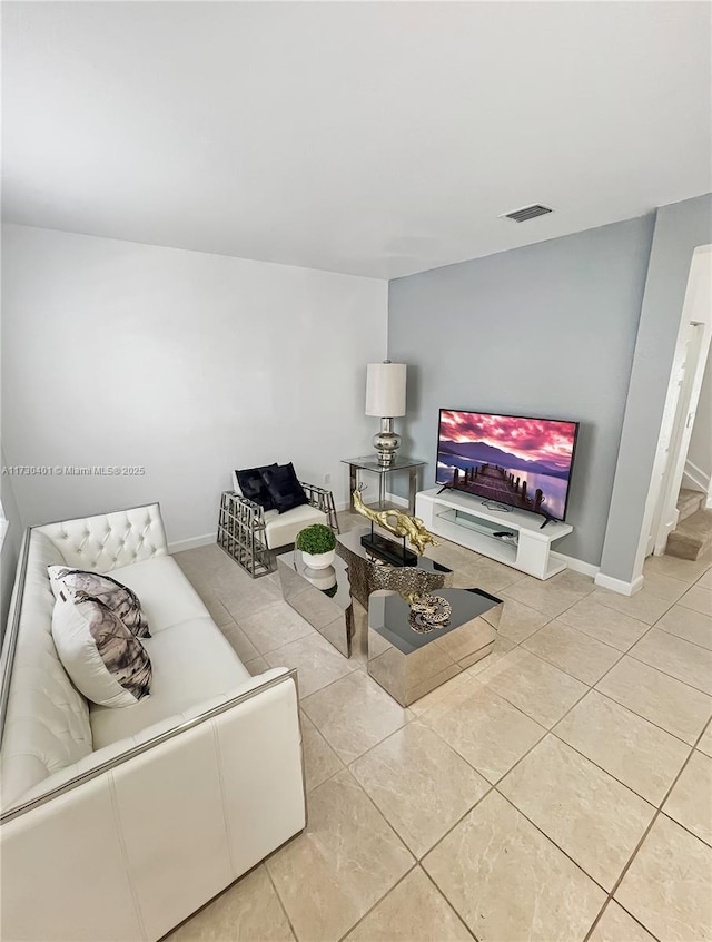 tiled living area featuring baseboards and visible vents