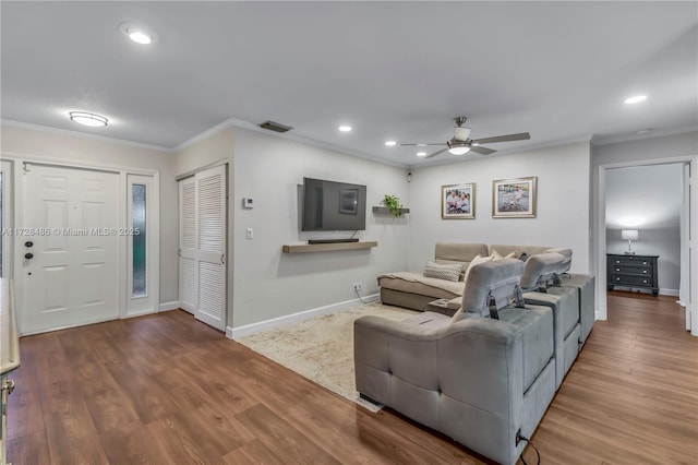 living room featuring hardwood / wood-style flooring, ceiling fan, and crown molding