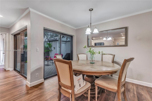 dining area featuring hardwood / wood-style floors, an inviting chandelier, and ornamental molding