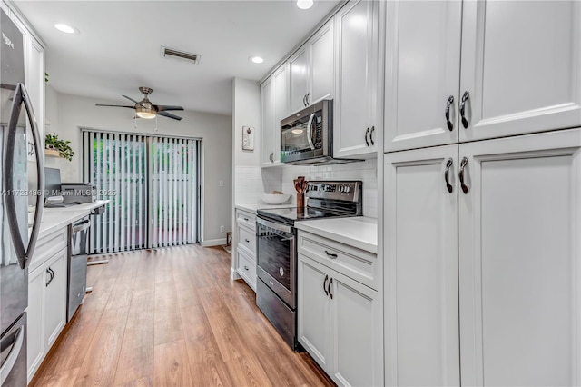 kitchen with ceiling fan, light hardwood / wood-style floors, white cabinetry, backsplash, and stainless steel appliances