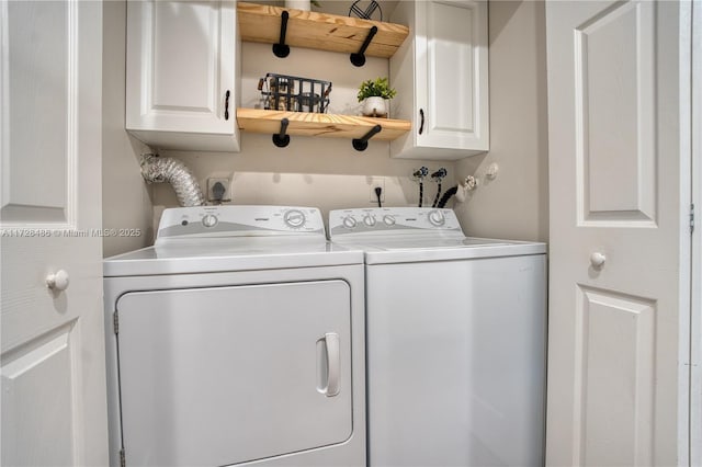 clothes washing area with cabinets and separate washer and dryer