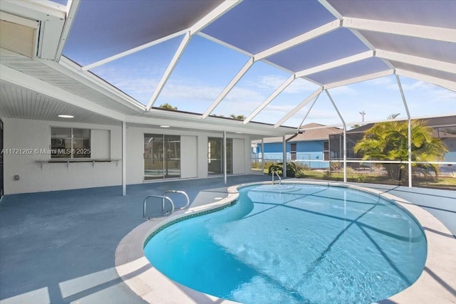 view of swimming pool featuring a lanai and a patio area