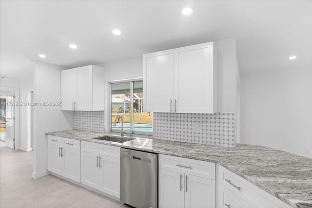 kitchen featuring sink, stainless steel dishwasher, white cabinets, and light stone counters