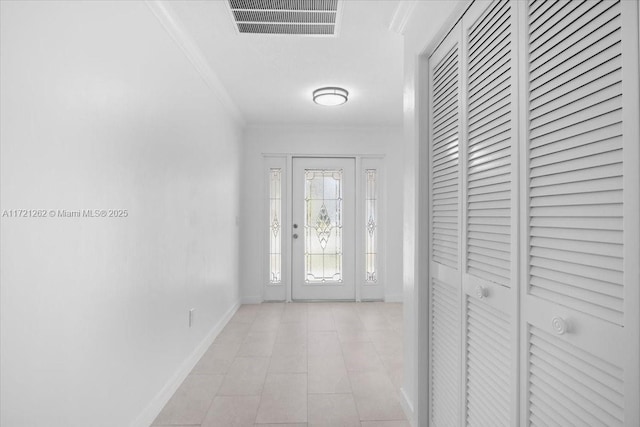 foyer entrance featuring crown molding and light tile patterned floors