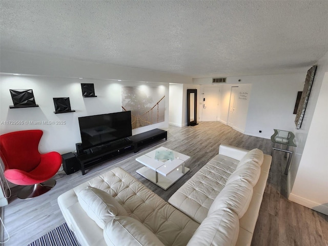 living room with wood-type flooring and a textured ceiling