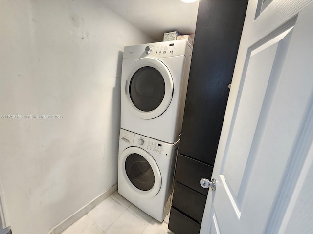 washroom featuring stacked washing maching and dryer and light tile patterned floors